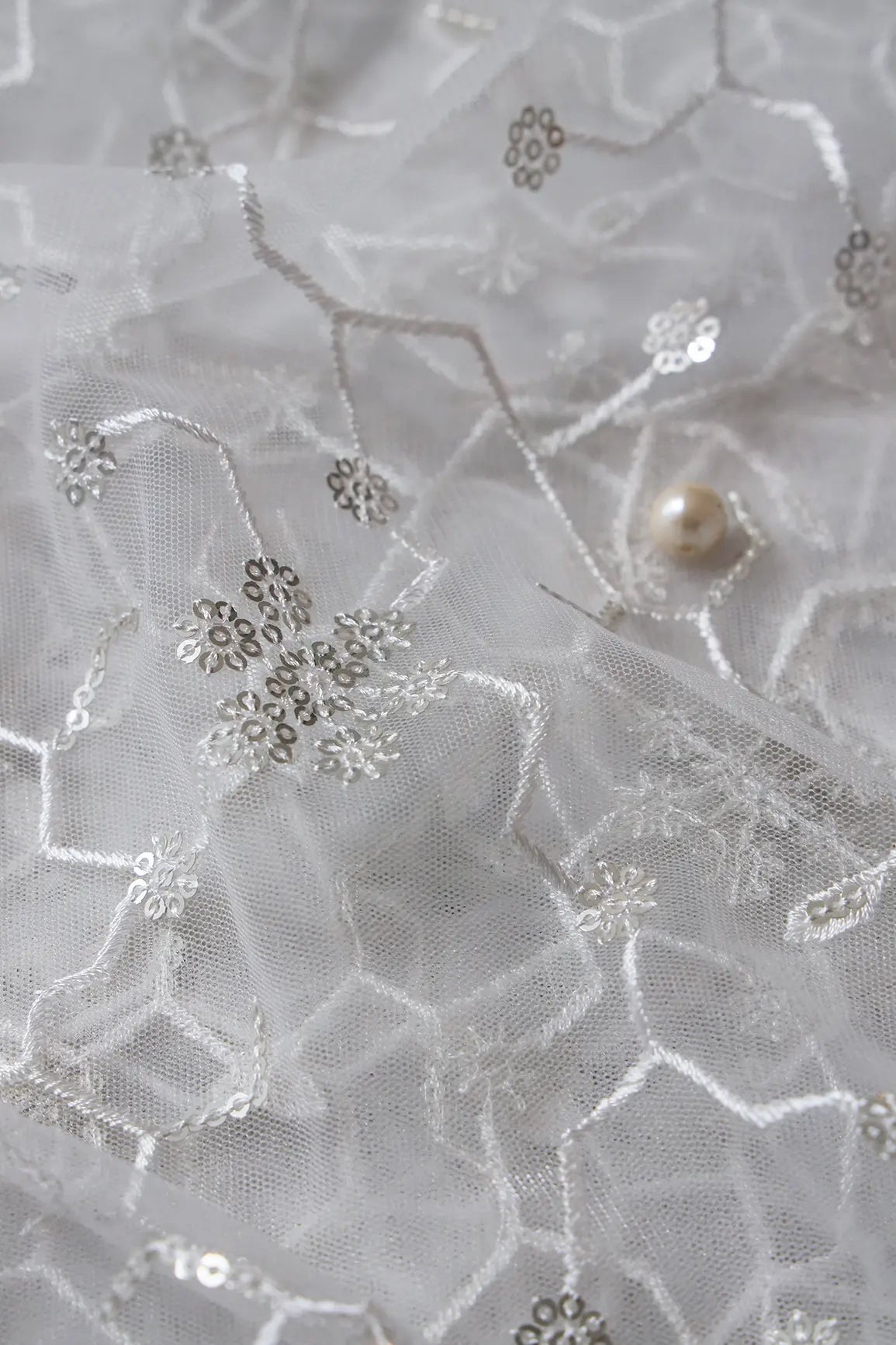 Beautiful Silver Sequins Small Floral Embroidery On White Dyeable Soft Net Fabric