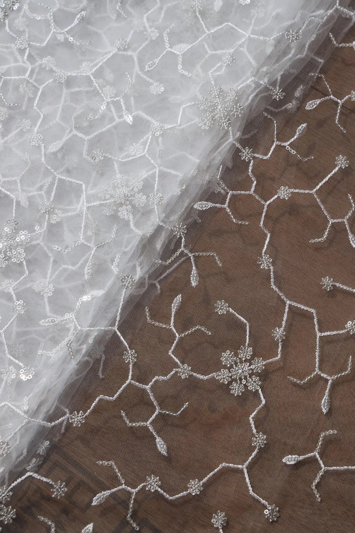 Beautiful Silver Sequins Small Floral Embroidery On White Dyeable Soft Net Fabric